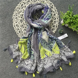 Detail of geometric wave patterns and yellow tassels on a bohemian linen scarf