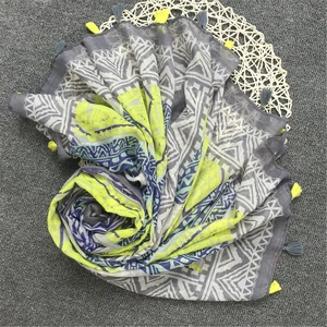 Detail of bohemian scarf with neon yellow geometric print and fringe tassels
