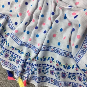 Nahaufnahme eines leichten Polka-Dot-Schals mit floraler Bordüre und bunten Quasten