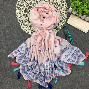 Detail eines rosa Baumwollschals mit bunten Punkten und 100% Viskose-Stoffstruktur