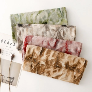 Detail of marble pattern scarves with gold specks on chiffon fabric in four colors