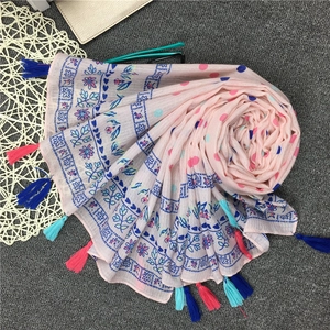 Nahaufnahme des rosa Baumwollschals mit Blumendruck und bunten Fransenquasten