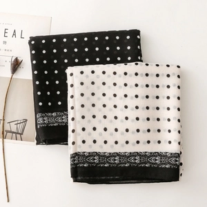 Detailed view of long polka dot scarves with elegant floral borders and light fabric