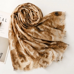 Detailed macro view of brown marble print scarf with delicate snow dot pattern texture