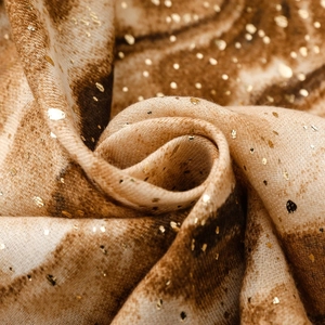 Macro shot of gradient linen scarf featuring metallic gold foiling and abstract textures