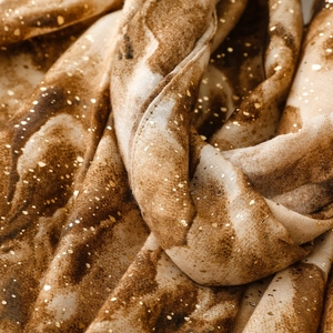 Detail of cotton linen scarf with gradient marble texture and metallic gold foil speckles