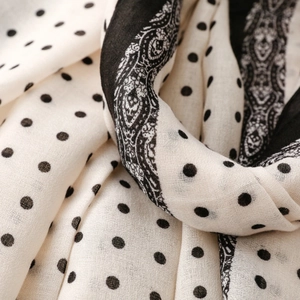 Detail of polka dot scarf showing beige cotton-linen texture and paisley border