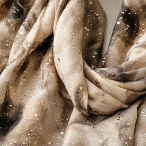 Macro shot of gradient marble print scarf with shimmering gold foil speckles detail