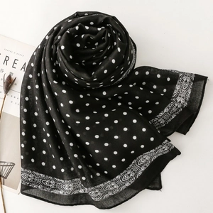 Close-up of black scarf with white polka dots and paisley floral border patterns