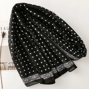 Detail shot of black scarf with white polka dots and delicate paisley border patterns