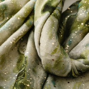 Detail of gradient ink print scarf with elegant gold foil stamping and linen texture