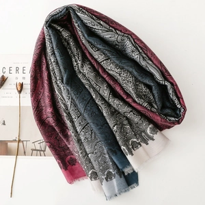 Écharpe ethnique à motif paisley avec franges, présentée avec un magazine sur blanc