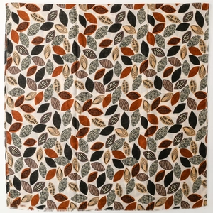 Detailed view of square scarf with leaf print patterns and fringed edges texture