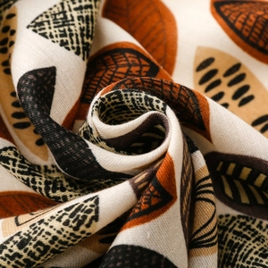 Detailed macro shot of abstract leaf print scarf with cotton-linen texture and fringe