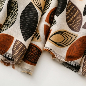 Close-up of cotton-linen scarf featuring vintage leaf prints and frayed fringe edges