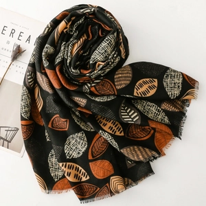 Detail of cotton-feel scarf with leaf patterns and elegant frayed fringe edges