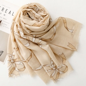 Écharpe aspect lin avec imprimé nœud et bordures effilochées sur tissu beige élégant