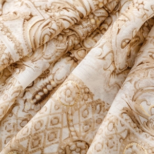 Détail macro d'une écharpe en coton et lin avec motif paisley doré et plis doux