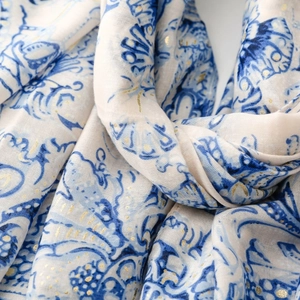 Gros plan d'une écharpe légère avec motif paisley bleu et détails en feuille d'or