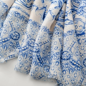 Détail d'une écharpe à motif cachemire bleu et blanc avec dorure et bords frangés