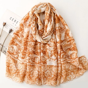 Détail d'un châle vintage aux motifs orange et bords doux à fines franges