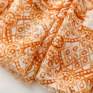 Vue détaillée du châle terracotta avec motifs paisley et dorures à la feuille