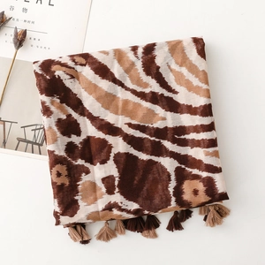 Detail von Schal mit Leoparden- und Zebramuster mit Fransen auf minimalistischem Hintergrund