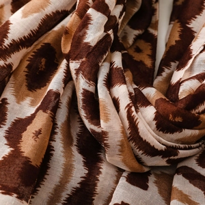 Nahaufnahme von dünnem Voile-Stoff mit braunem Ikat-Zebramuster und Fransen-Detail