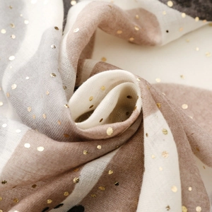 Detail eines Baumwoll-Leinen-Schals mit Goldfolien-Punkten und gestreifter Textur