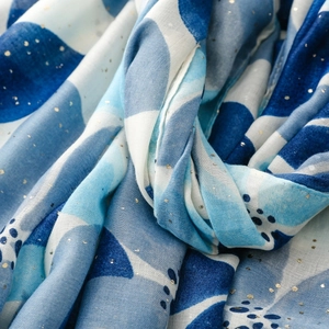 Detail eines blauen Aquarellschals mit schimmernden Goldpunkten und weichem Stoff