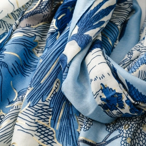 Détail de l'écharpe en coton-lin bleu avec imprimé forêt tropicale dorée et texture fine
