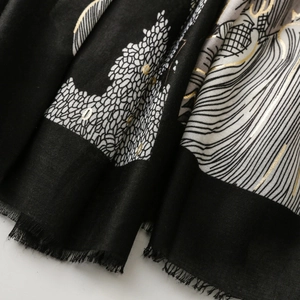 Détail de l'écharpe en coton-lin avec imprimé jungle doré et bords à franges