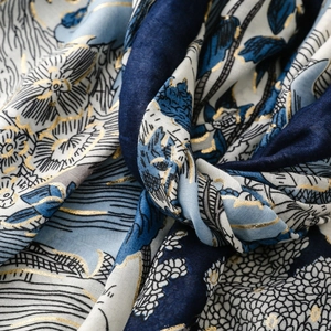 Détail macro de l'imprimé forêt tropicale dorée sur tissu écharpe aspect lin bleu