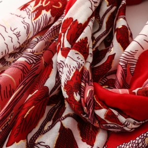 Détail de l'écharpe en coton et lin avec feuilles rouges et dorure à chaud dorée