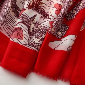 Gros plan d'une écharpe rouge et blanche avec motifs de forêt tropicale en feuille d'or