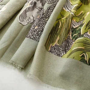 Détail macro de l'écharpe en coton et lin vert clair avec motifs de feuilles dorées