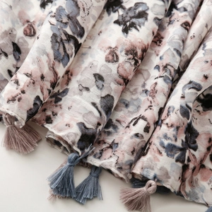 Close-up of ink-wash floral print linen scarf with delicate handmade fringe tassels