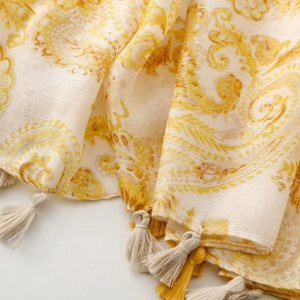 Detail of yellow paisley cotton linen scarf with woven fringe edges and bohemian texture