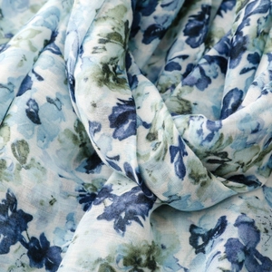 Detail shot of light breathable scarf fabric with blue and green floral print patterns