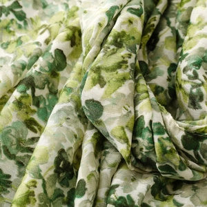 Detailed macro view of soft green floral print linen-feel fabric with artistic texture