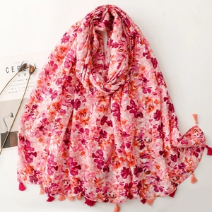 Pink floral print shawl scarf with tassels laid flat on a clean minimalist background