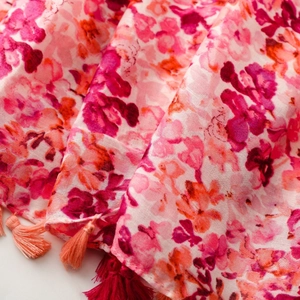 Close-up of lightweight cotton linen scarf with floral patterns and delicate silk tassels