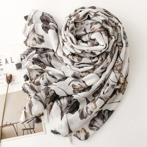 Detailed view of lightweight shawl with ginkgo leaf prints and black and white tassels