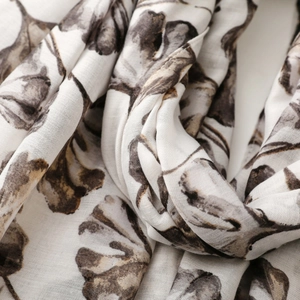 Close-up of lightweight scarf featuring elegant ginkgo leaf print and soft fabric texture