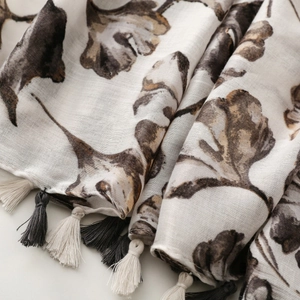 Close-up of lightweight botanical print shawl with two-tone tassel fringe detail