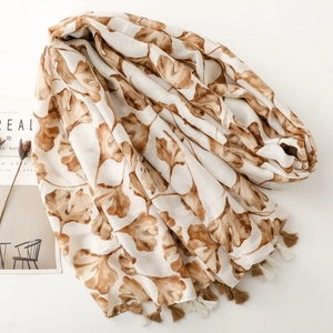 Detail of elegant leaf print scarf with tassels on lightweight translucent fabric