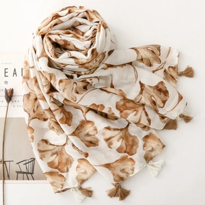 Detailed close-up of ginkgo leaf print scarf with elegant fringe and woven texture