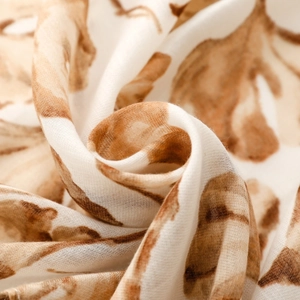 Detailed macro shot of soft cream fabric with elegant brown ginkgo leaf printing
