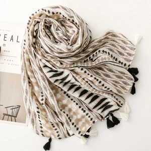 Macro view of geometric wave patterns and fringe on a soft cotton linen texture scarf