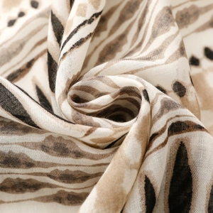 Macro shot of cotton linen scarf texture featuring abstract geometric patterns and tassels
